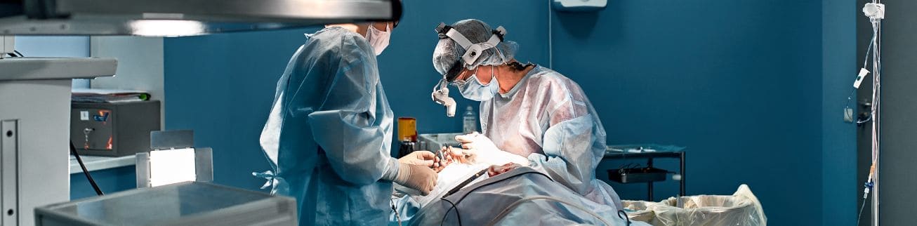 Two doctors operating on a patient in a hospital theatre