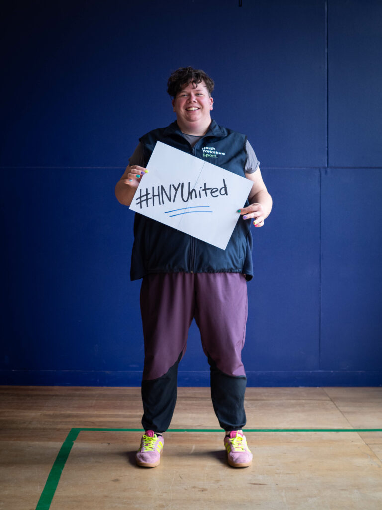 Laura Harris, the Sport Welfare Manager with North Yorkshire Sport, holds up a sign saying #HNYUnited