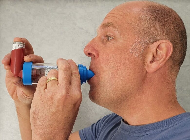 Man using preventer inhaler with spacer